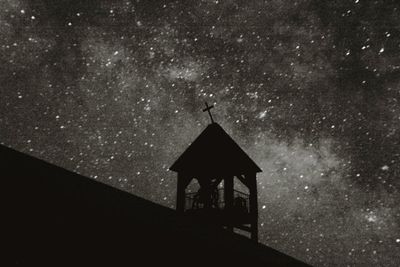 Low angle view of clock tower against sky at night