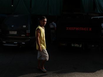 Side view of a man standing in the dark