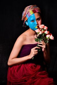 Portrait of a beautiful young woman holding flower