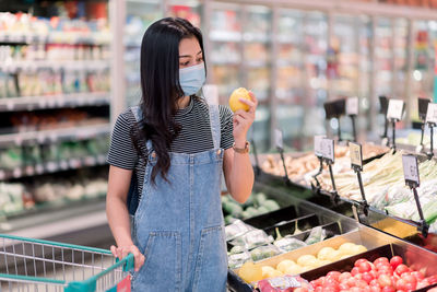 Midsection of woman holding ice cream at store