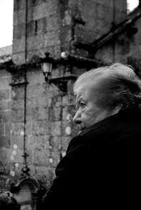 Portrait of man looking away against building