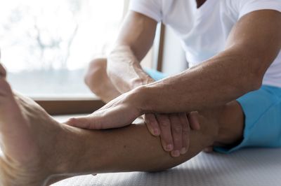 Low section of man stretching at gym