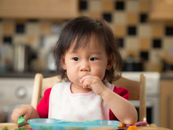 Portrait of cute girl sitting at home