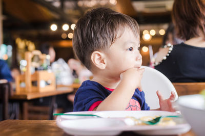 Cute baby boy having meal at restaurant