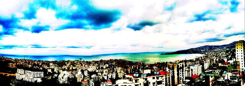 View of cityscape against cloudy sky