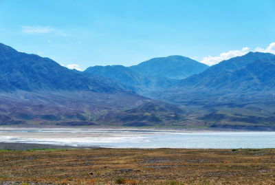 Scenic view of sea and mountains against sky