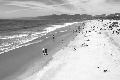 People at beach against sky