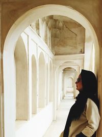 Side view of woman walking in corridor of building