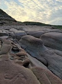 Rocks on land against sky during sunset