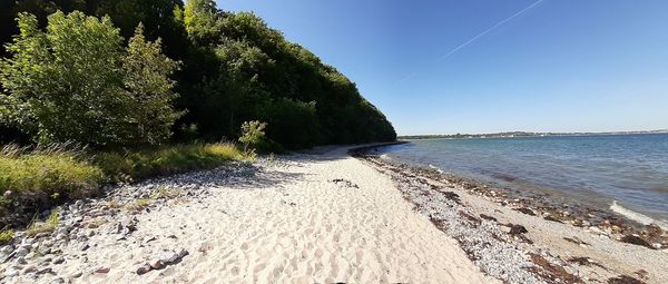 Scenic view of beach against clear blue sky