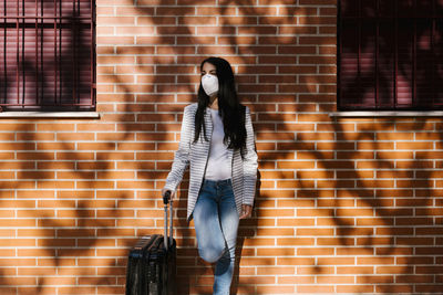 Woman standing against brick wall