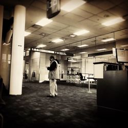 Rear view of woman standing in corridor