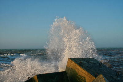 Water splashing in sea against clear sky