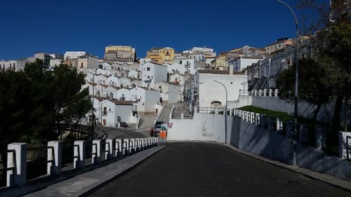 Street amidst buildings in city against clear sky