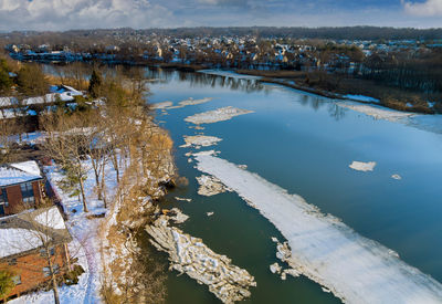 Scenic view of lake by buildings during winter
