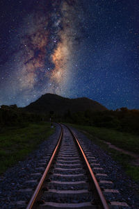 Diminishing perspective of railroad track against star field at night