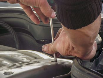 Cropped hands of mechanic repairing car