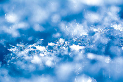 Full frame shot of snowflakes on blue sky