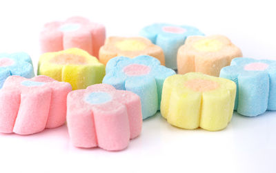 Close-up of multi colored candies against white background