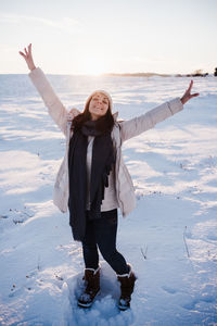 Happy young woman hiking in snowy mountain wearing modern coat at sunset. winter season. nature