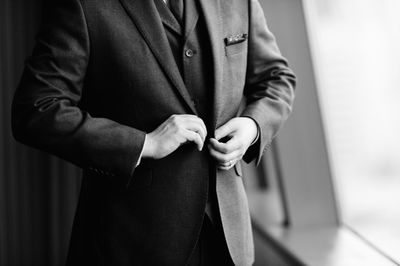 Midsection of man wearing suit