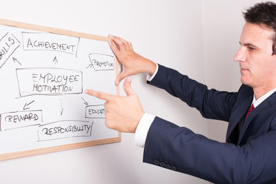 Businessman pointing on whiteboard at office