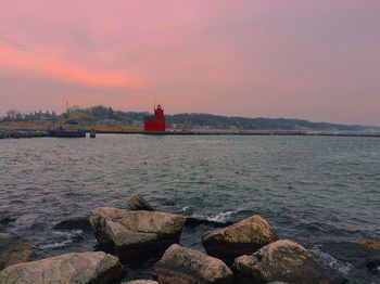 Scenic view of sea against cloudy sky at sunset