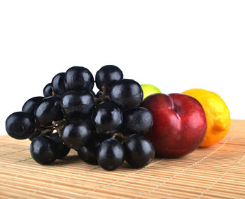 Close-up of grapes on table against white background