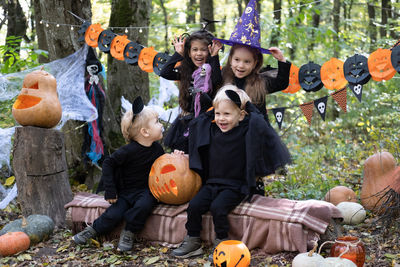 Happy kids in halloween costumes having fun in halloween decorations outdoor