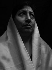 Portrait of young man against black background