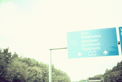 Low angle view of information sign against clear blue sky