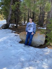 Full length of young man standing by tree in forest