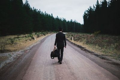 Rear view of woman walking on road