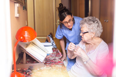 Angry senior woman with her caregiver at home. senior home care concept.