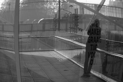 Man seen through railing bridge