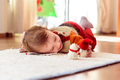 Baby girl lying on carpet at home