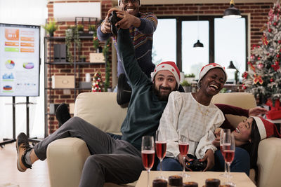 Portrait of smiling friends sitting on table