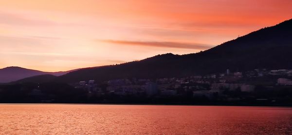 Scenic view of silhouette mountains against romantic sky at sunset