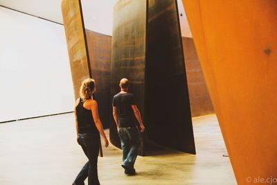 Rear view of people walking on bridge