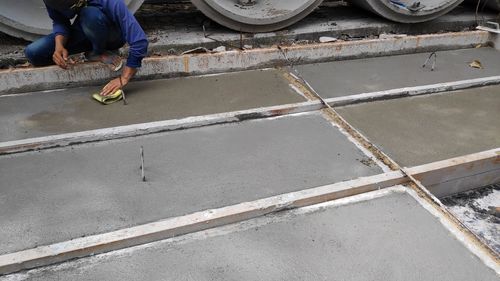 Low section of man standing on concrete floor