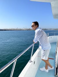 Rear view of man standing in boat