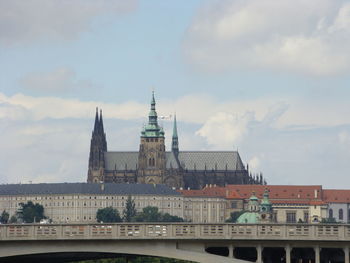 St vitus cathedral in prague against cloudy sky above the bridge