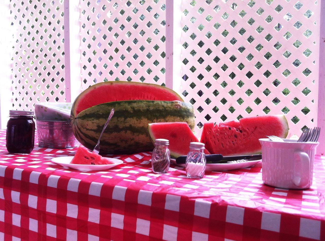 indoors, chair, table, red, still life, empty, absence, furniture, home interior, seat, tablecloth, no people, wall - building feature, glass - material, day, textile, potted plant, plastic, window, place setting