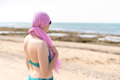 Rear view of woman standing on beach