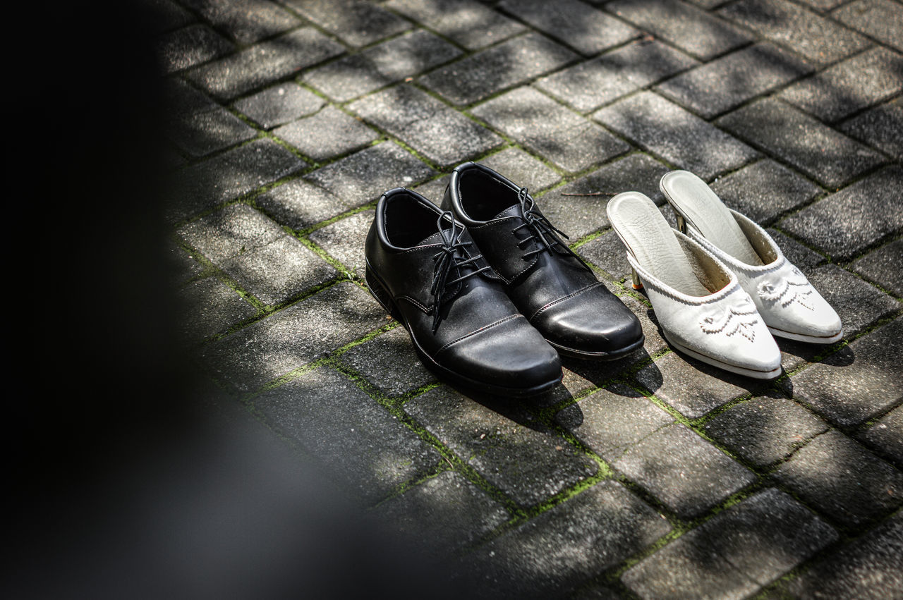 HIGH ANGLE VIEW OF BLACK SHOES ON STREET