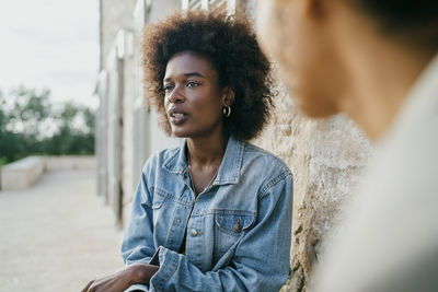 Young woman sitting with female friend in backyard