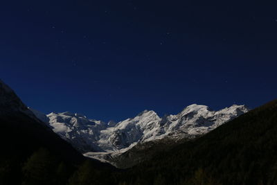Low angle view of snowcapped mountain at night