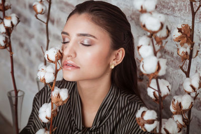 Close-up of woman by cotton flowers