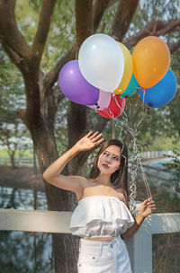 Rear view of woman holding balloons