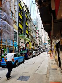 People on street amidst buildings in city